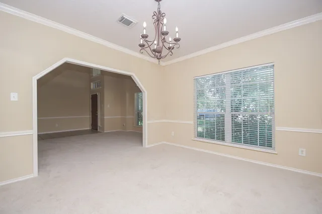 a view of a livingroom with a chandelier fan and windows