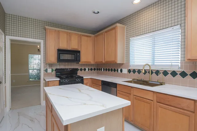 a kitchen with granite countertop a sink and a stove
