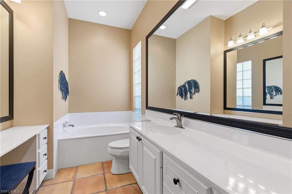 5902 Bermuda Lane Naples, FL 34119 - Photo 12 of 18 a bathroom with a double vanity sink a toilet a mirror and shower