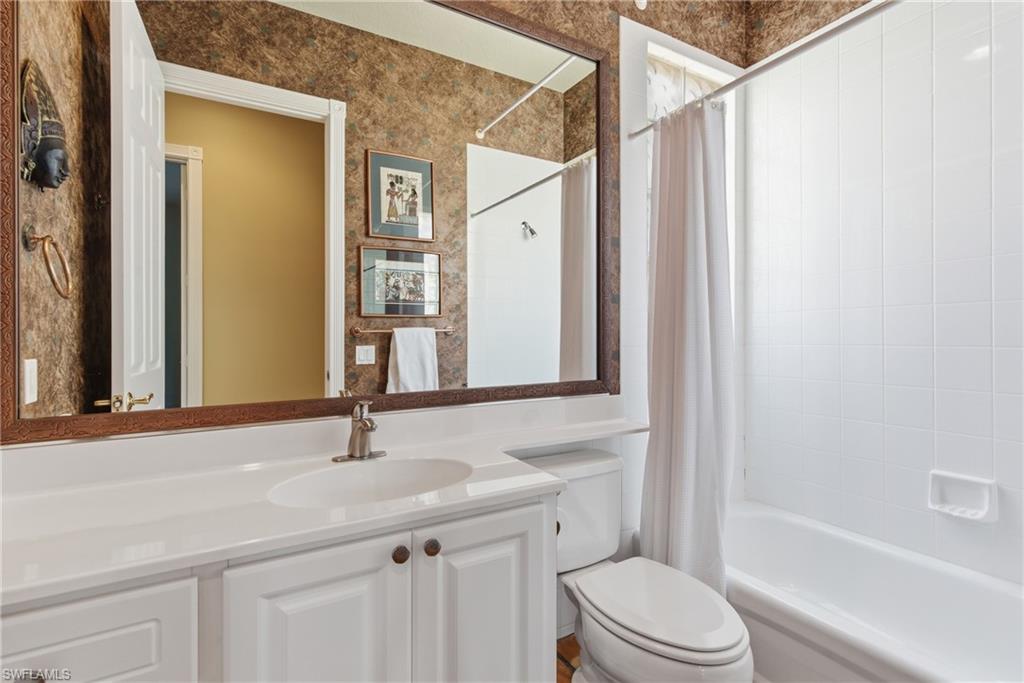 5902 Bermuda Lane Naples, FL 34119 - Photo 14 of 18 a bathroom with a sink a toilet and a mirror