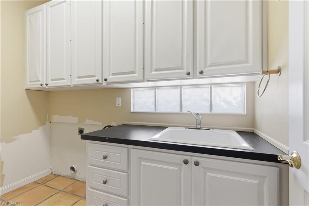 5902 Bermuda Lane Naples, FL 34119 - Photo 16 of 18 a kitchen with granite countertop white cabinets and sink