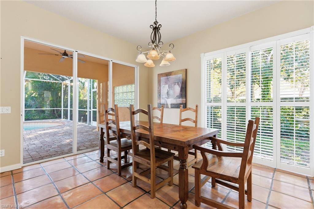 5902 Bermuda Lane Naples, FL 34119 - Photo 7 of 18 a view of a dining room with furniture large windows and chandelier