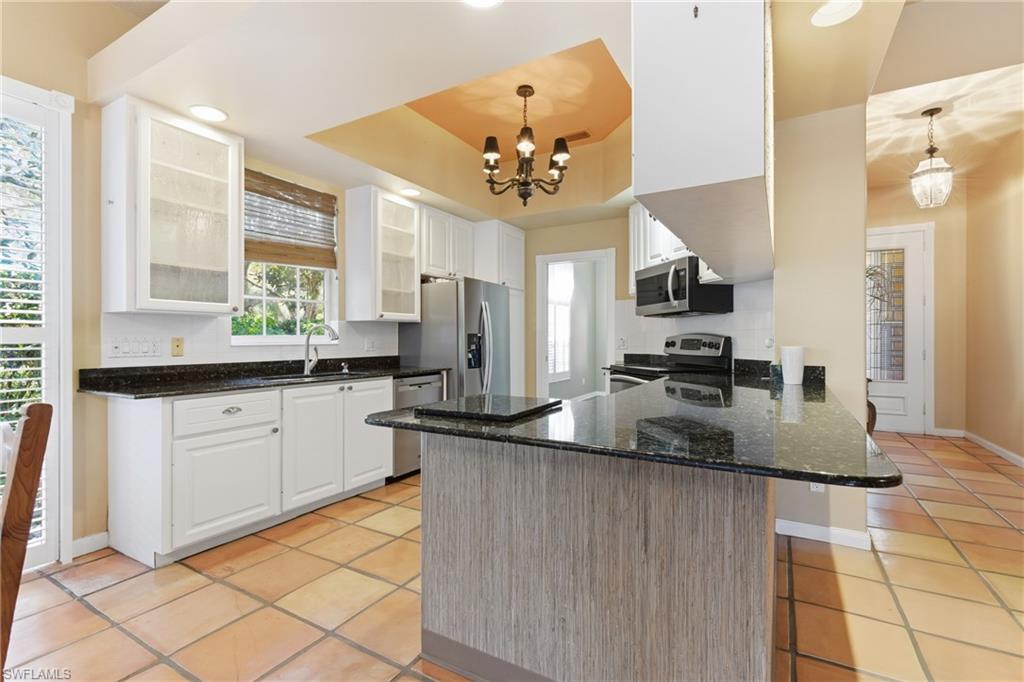 5902 Bermuda Lane Naples, FL 34119 - Photo 8 of 18 a kitchen with stainless steel appliances granite countertop a sink a stove counter space and cabinets