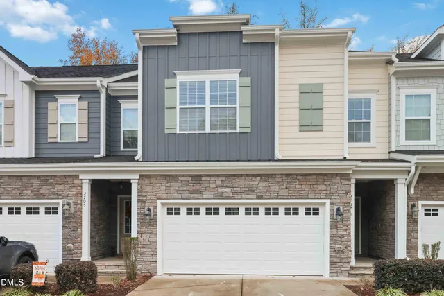 a front view of a building with a yard and a garage