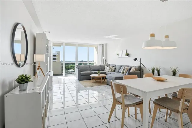 a living room with furniture a table and kitchen view