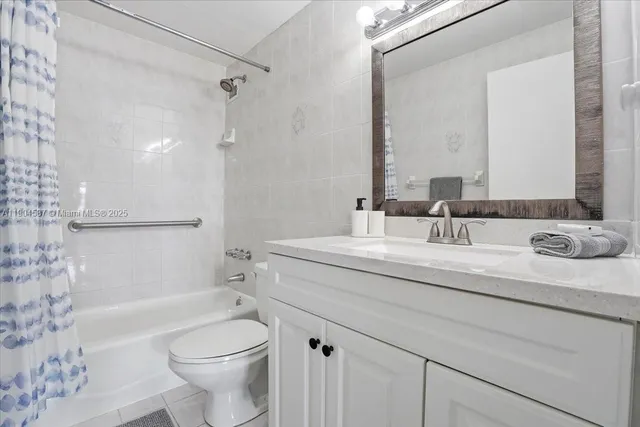 a bathroom with a granite countertop sink a toilet and shower