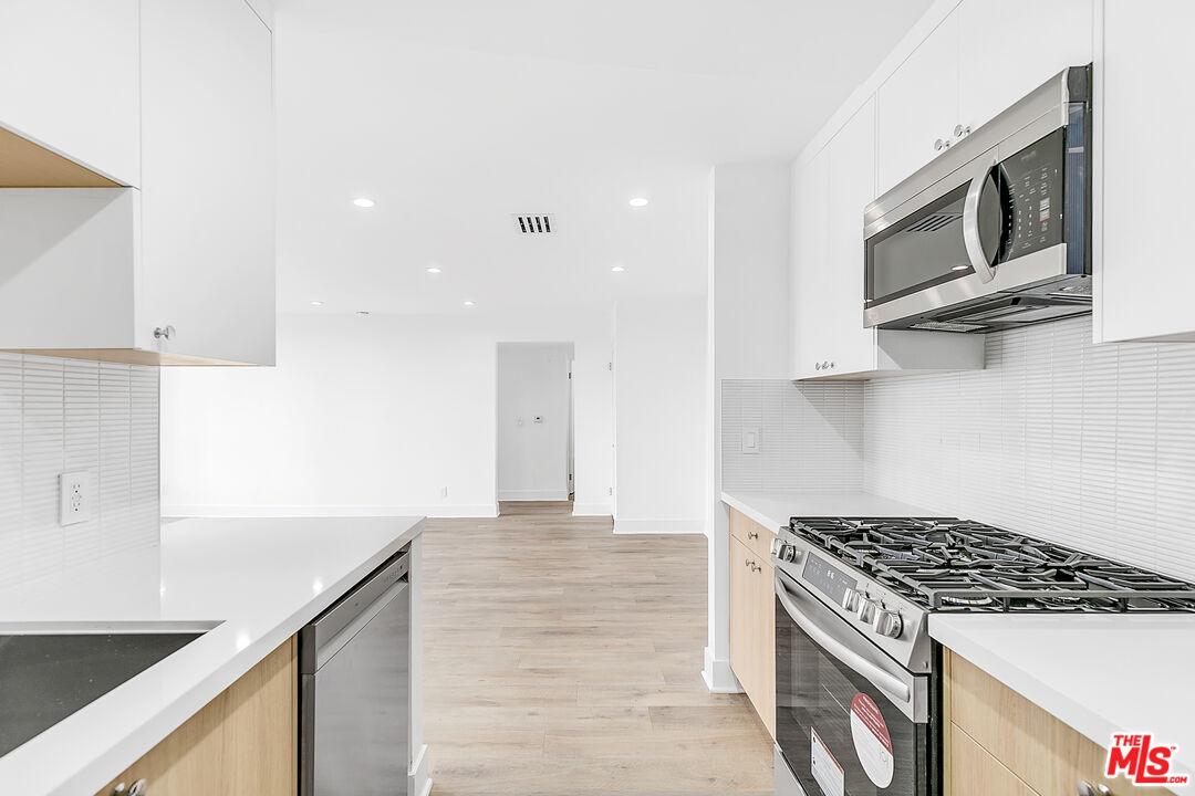 4115 Normal Avenue Los Angeles, CA 90029 - Photo 5 of 7 a kitchen with stainless steel appliances granite countertop a sink and a stove