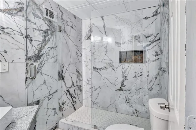 a bathroom with a toilet sink and shower curtain
