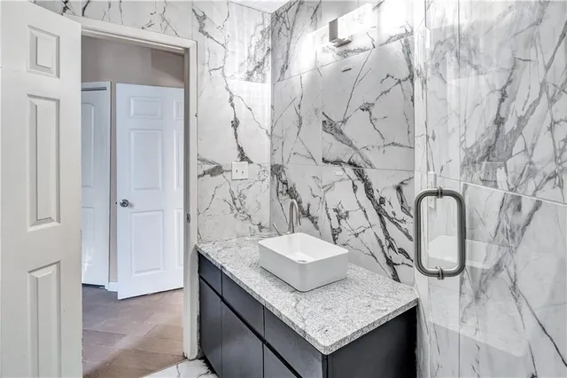 a bathroom with a granite countertop sink and a mirror