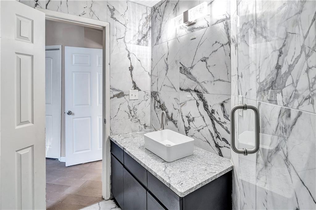 1920 Moores Mill Road Northwest Atlanta, GA 30318 - Photo 16 of 33 a bathroom with a granite countertop sink and a mirror