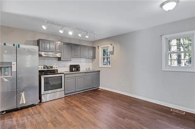 a kitchen with stainless steel appliances granite countertop a refrigerator and a stove top oven
