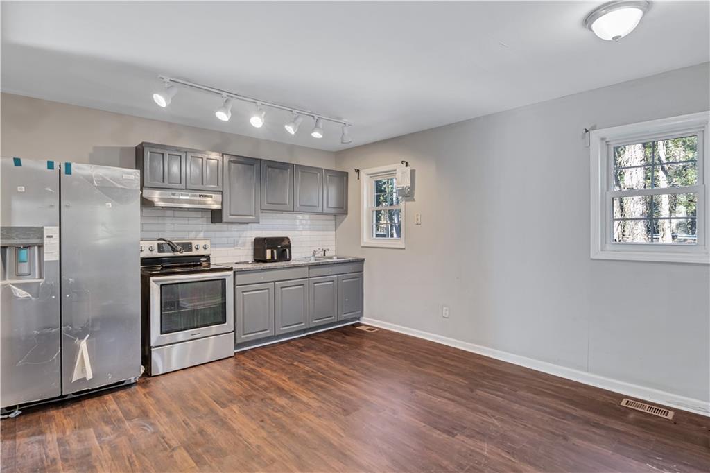 1920 Moores Mill Road Northwest Atlanta, GA 30318 - Photo 22 of 33 a kitchen with stainless steel appliances granite countertop a refrigerator and a stove top oven