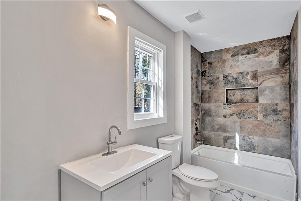 1920 Moores Mill Road Northwest Atlanta, GA 30318 - Photo 25 of 33 a bathroom with a bathtub shower sink mirror and toilet