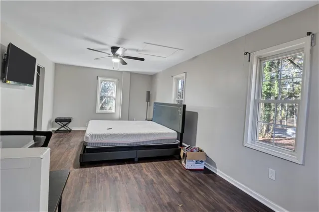 a bedroom with a bed and a flat tv screen on the dresser