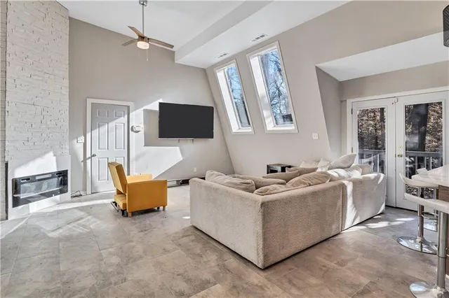 a living room with furniture a large window and a flat screen tv