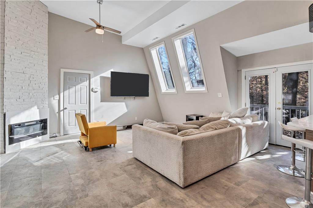 1920 Moores Mill Road Northwest Atlanta, GA 30318 - Photo 3 of 33 a living room with furniture a large window and a flat screen tv
