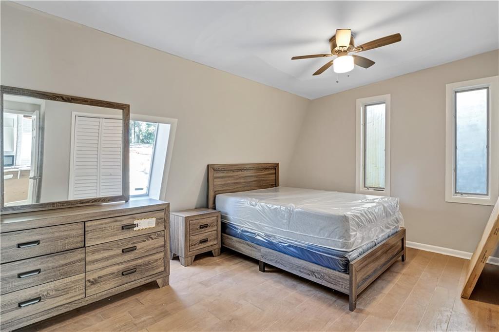 1920 Moores Mill Road Northwest Atlanta, GA 30318 - Photo 9 of 33 a bedroom with a bed and a chandelier