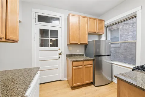 a kitchen with stainless steel appliances granite countertop a refrigerator and a stove