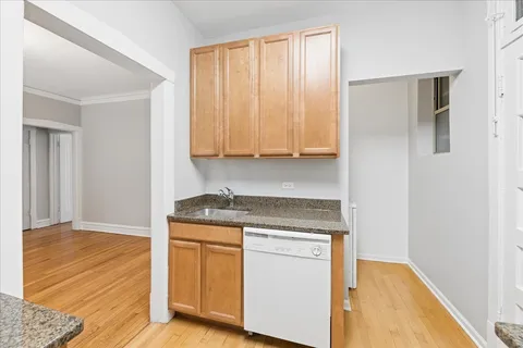 a kitchen with granite countertop cabinets appliances and a wooden floor