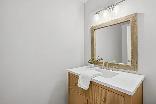 a bathroom with a sink vanity and a mirror