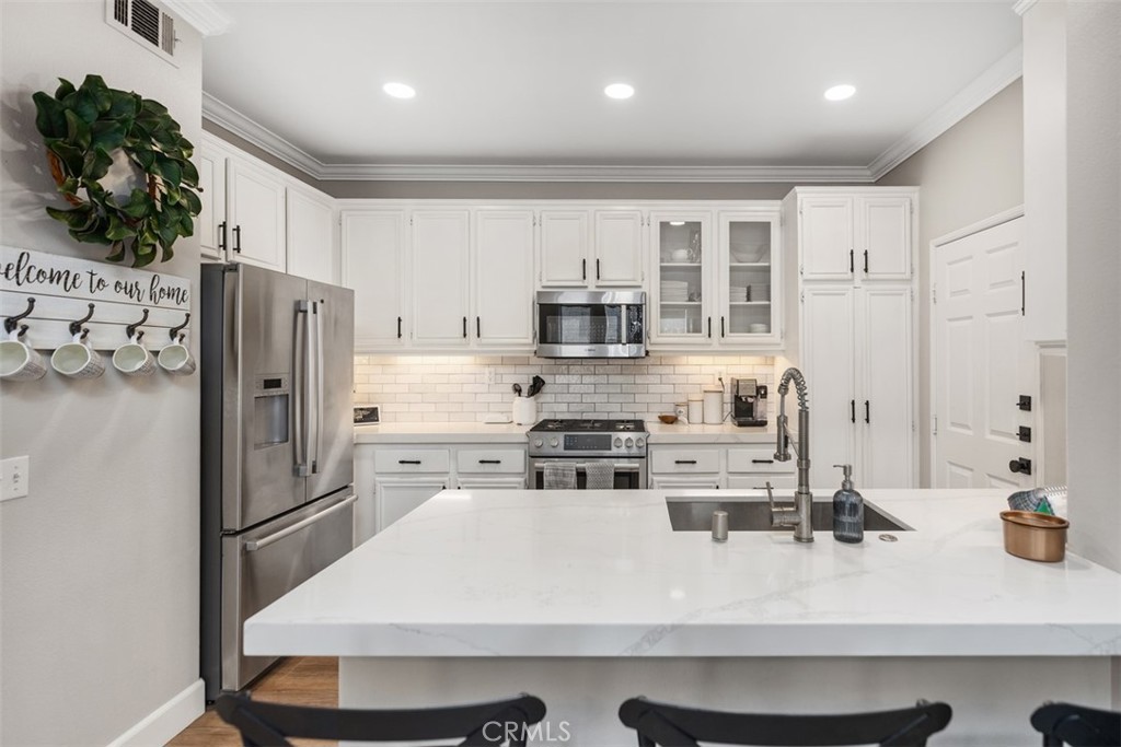 42 Livingston Place Ladera Ranch, CA 92694 - Photo 14 of 34 a kitchen with stainless steel appliances a refrigerator stove microwave and sink