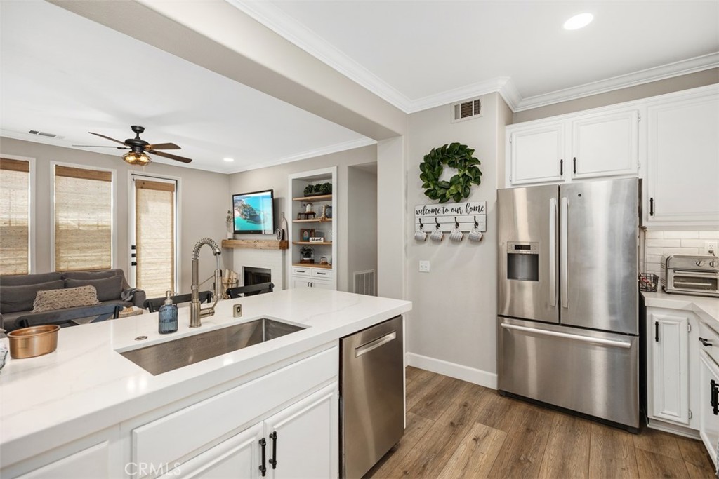 42 Livingston Place Ladera Ranch, CA 92694 - Photo 17 of 34 a kitchen with stainless steel appliances a sink a refrigerator and wooden floor