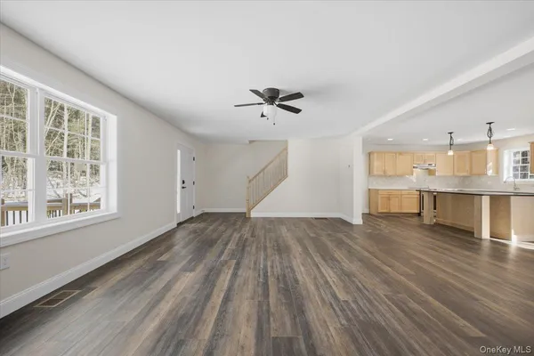 a kitchen with stainless steel appliances granite countertop a refrigerator a sink a stove and white cabinets