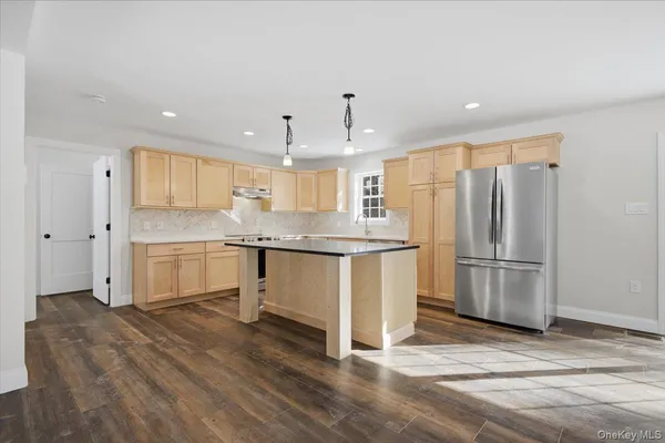 a view of a big room with wooden floor and windows