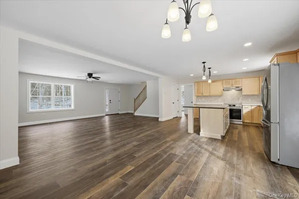 a kitchen with granite countertop a stove and white cabinets with wooden floor