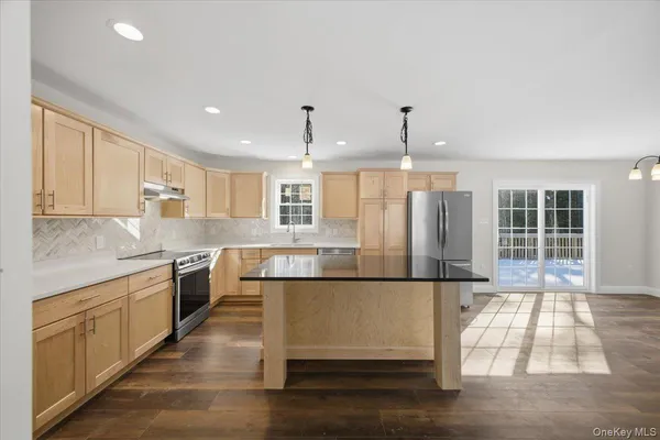 a kitchen with stainless steel appliances granite countertop a sink a stove and a refrigerator