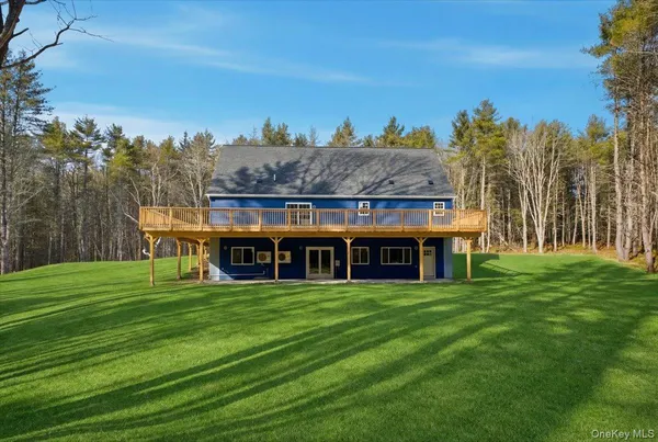 a view of a house with a big yard and large trees