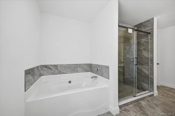 a bathroom with a bathtub shower sink and mirror