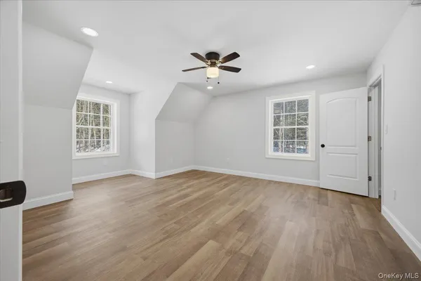 a view of empty room with wooden floor and window