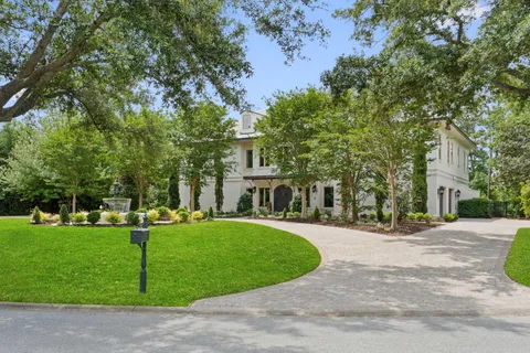 a view of staircase with lots of frames on wall and a window