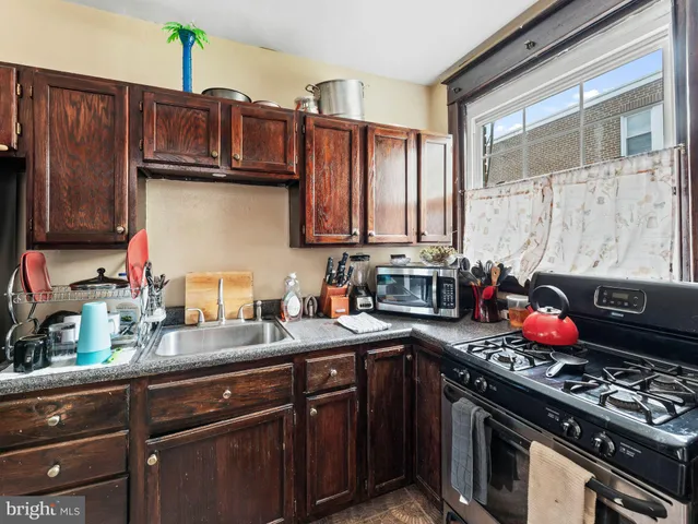 a kitchen with granite countertop a stove sink and cabinets