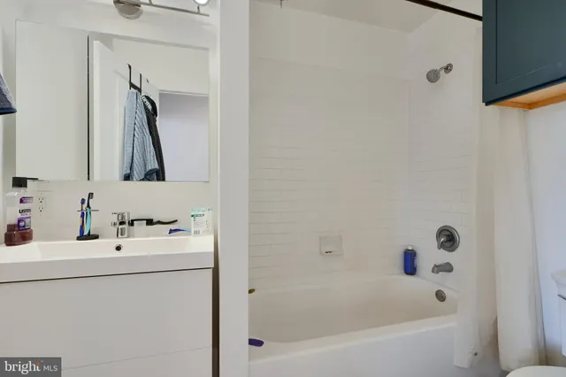 a bathroom with a tub sink and mirror