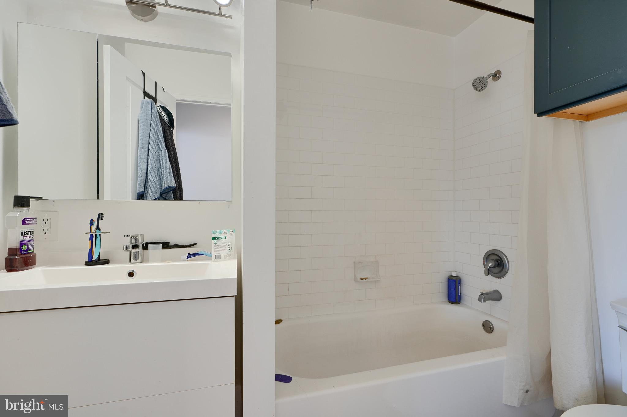1729 Guilford Avenue, Unit 2 Baltimore, MD 21202 - Photo 11 of 15 a bathroom with a tub sink and mirror