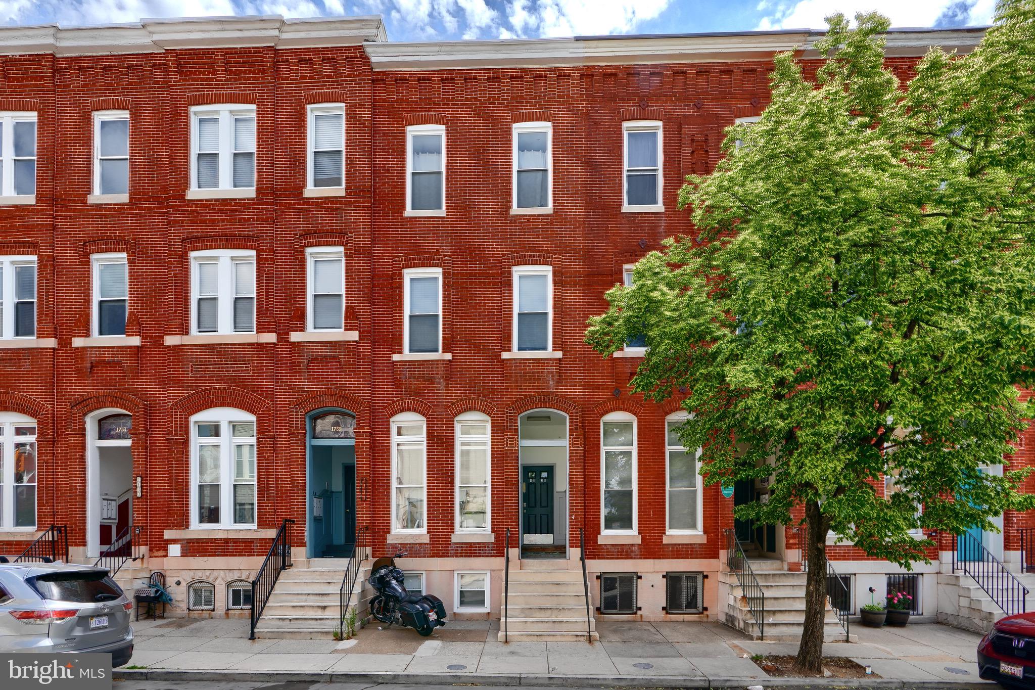 1729 Guilford Avenue, Unit 2 Baltimore, MD 21202 - Photo 2 of 15 a front view of a building with lots of trees and plants