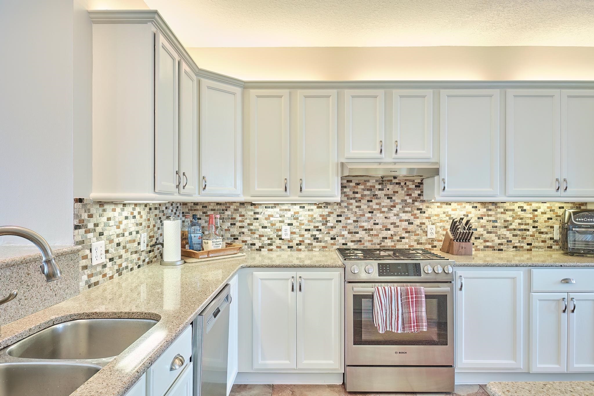 9257 July Lane St. Augustine, FL 32080 - Photo 18 of 48 a kitchen with granite countertop a sink and cabinets