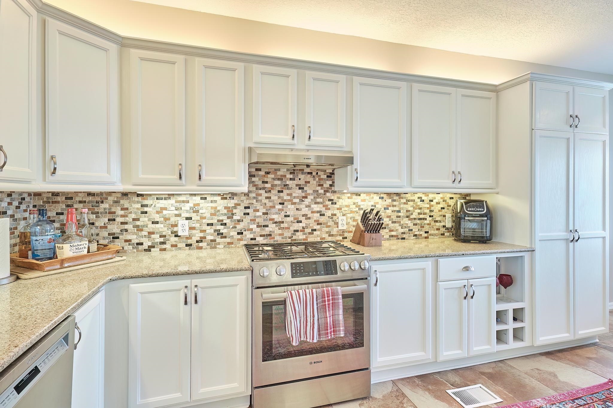 9257 July Lane St. Augustine, FL 32080 - Photo 19 of 48 a kitchen with granite countertop white cabinets and sink