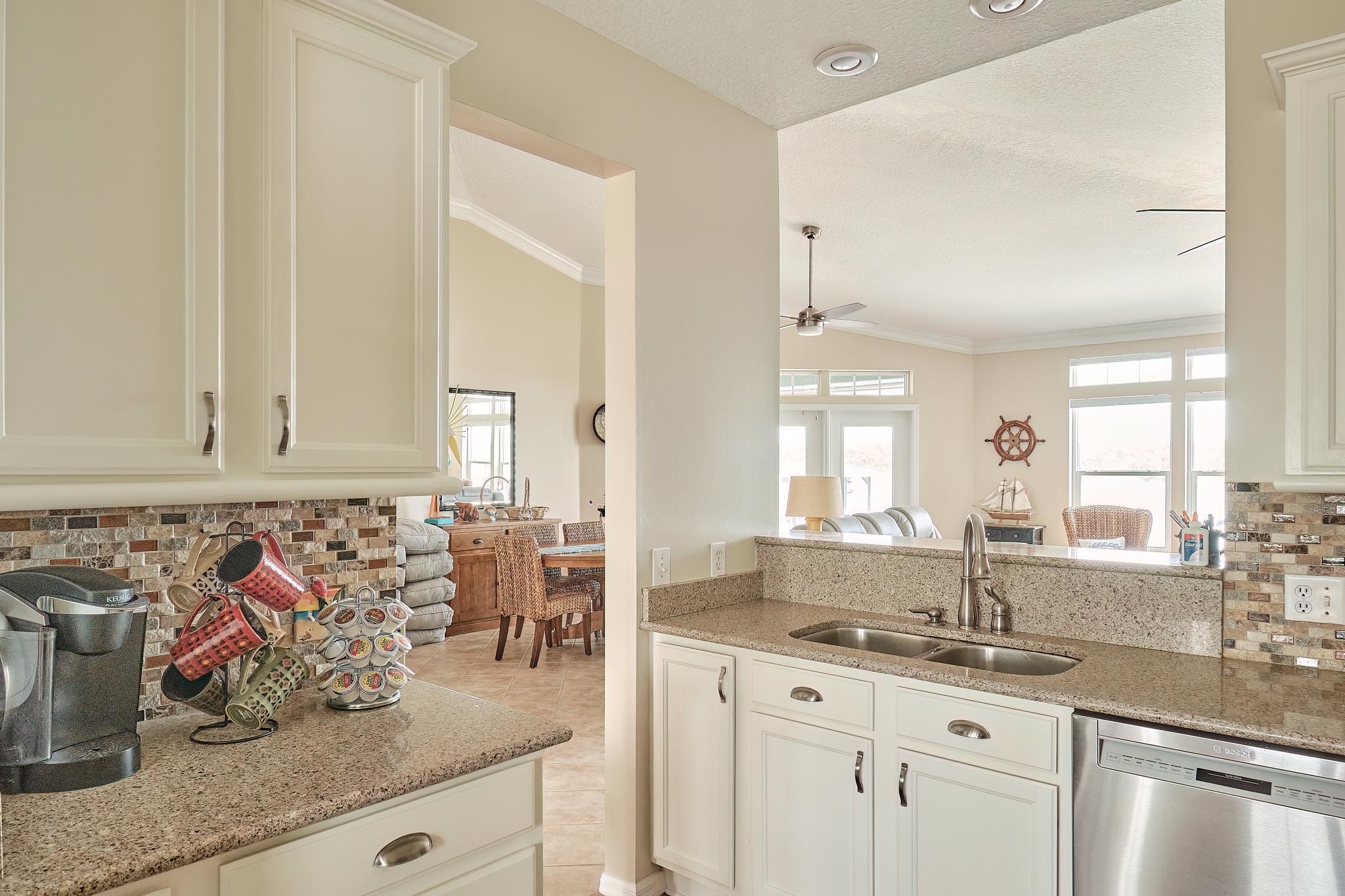 9257 July Lane St. Augustine, FL 32080 - Photo 23 of 48 a kitchen with stainless steel appliances granite countertop a sink and a wooden cabinets