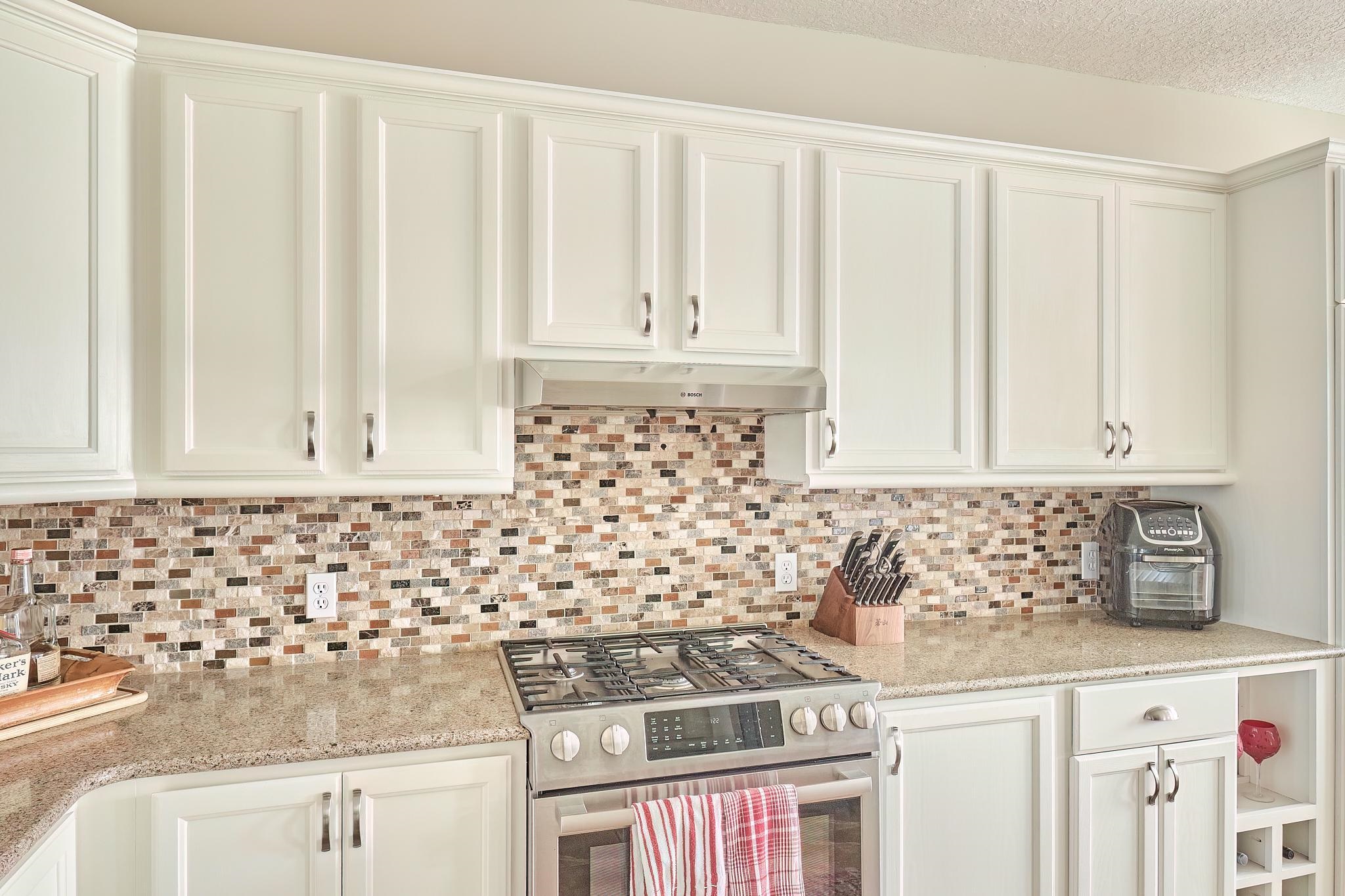 9257 July Lane St. Augustine, FL 32080 - Photo 24 of 48 a kitchen with granite countertop a stove and a white cabinet