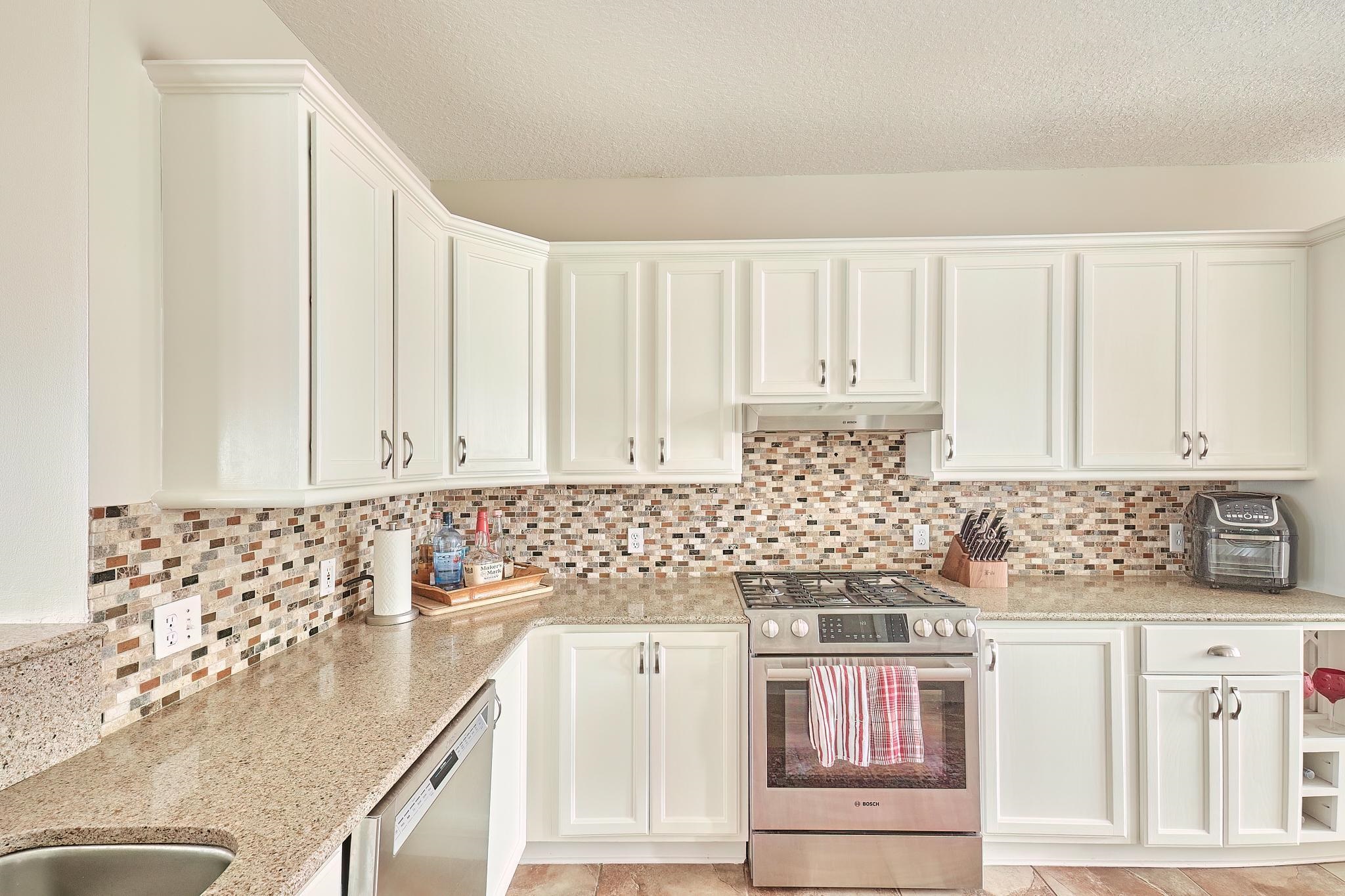 9257 July Lane St. Augustine, FL 32080 - Photo 25 of 48 a kitchen with granite countertop white cabinets and white appliances