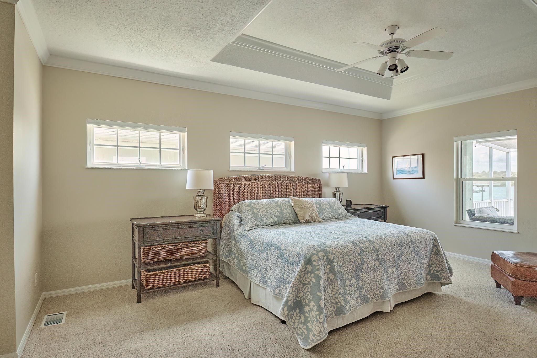 9257 July Lane St. Augustine, FL 32080 - Photo 26 of 48 a bedroom with a bed a chandelier and dresser