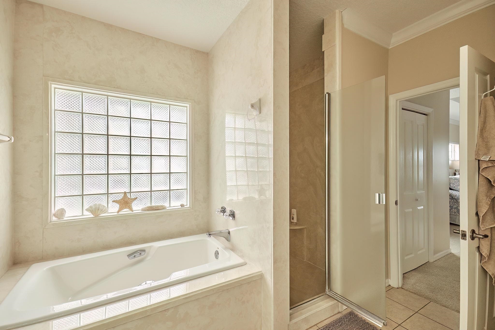 9257 July Lane St. Augustine, FL 32080 - Photo 31 of 48 a bathroom with a bathtub and a shower