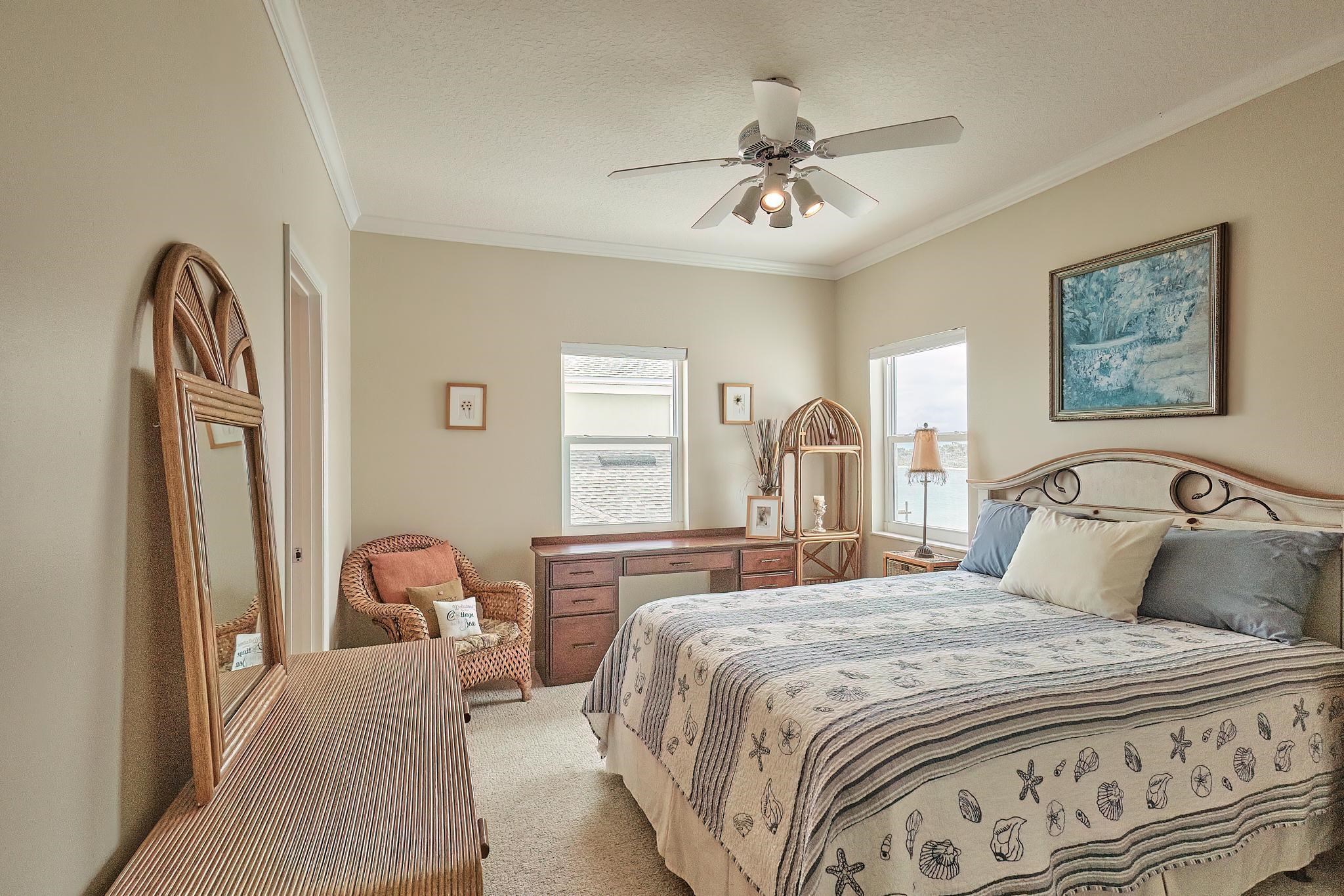 9257 July Lane St. Augustine, FL 32080 - Photo 37 of 48 a bedroom with a large bed and a chandelier