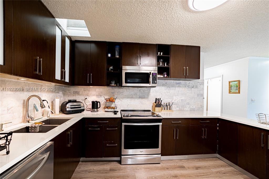 402 St Andrews Road, Unit 55 Hollywood, FL 33021 - Photo 4 of 14 a kitchen with a sink and a stove top oven