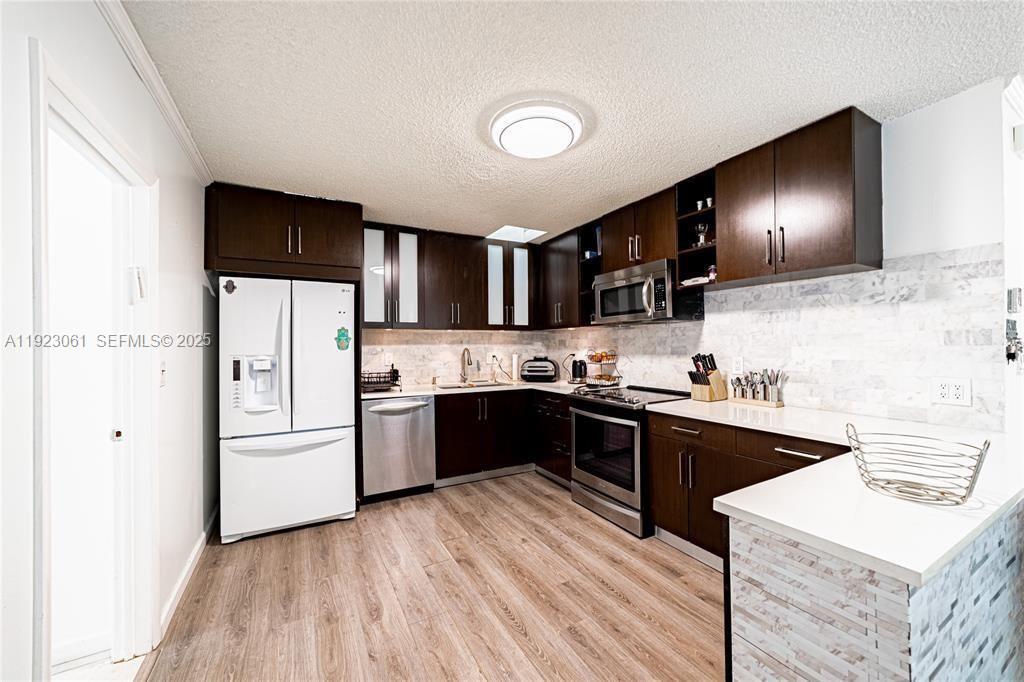 402 St Andrews Road, Unit 55 Hollywood, FL 33021 - Photo 5 of 14 a kitchen with stainless steel appliances kitchen island granite countertop a sink stove and refrigerator