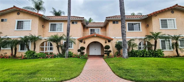 a front view of a house with a garden and plants