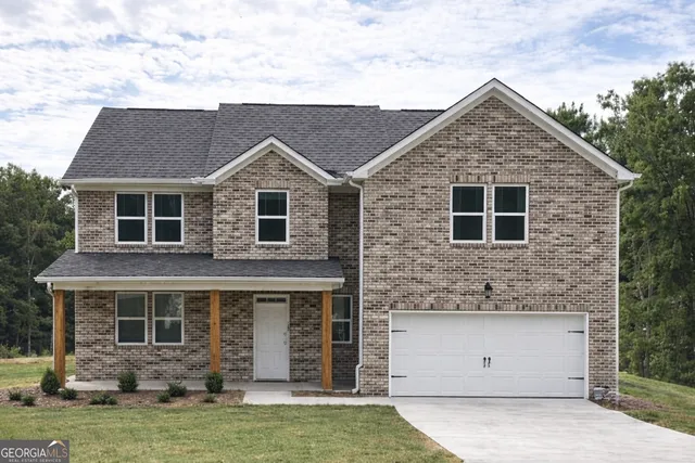 a front view of a house with a garden and garage